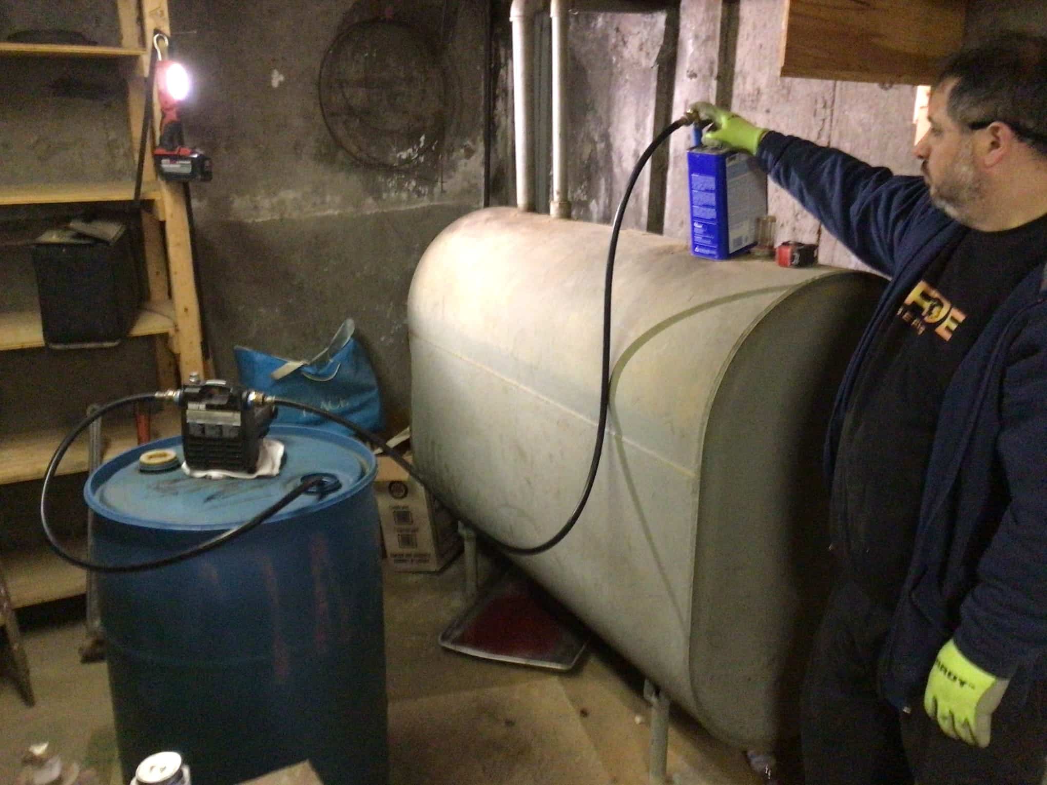 Worker performing oil tank service before Pride Services in Rockville Centre, NY