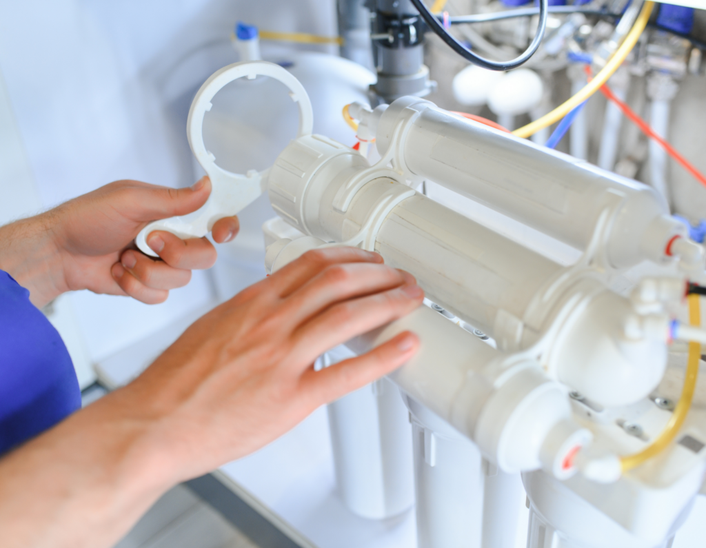 Technician servicing a reverse osmosis water filtration system in a Rockville Centre, NY home.